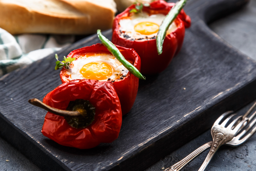 Baked red peppers stuffed with eggs and sausage with bread and green beans, close view — Stock Photo, Image