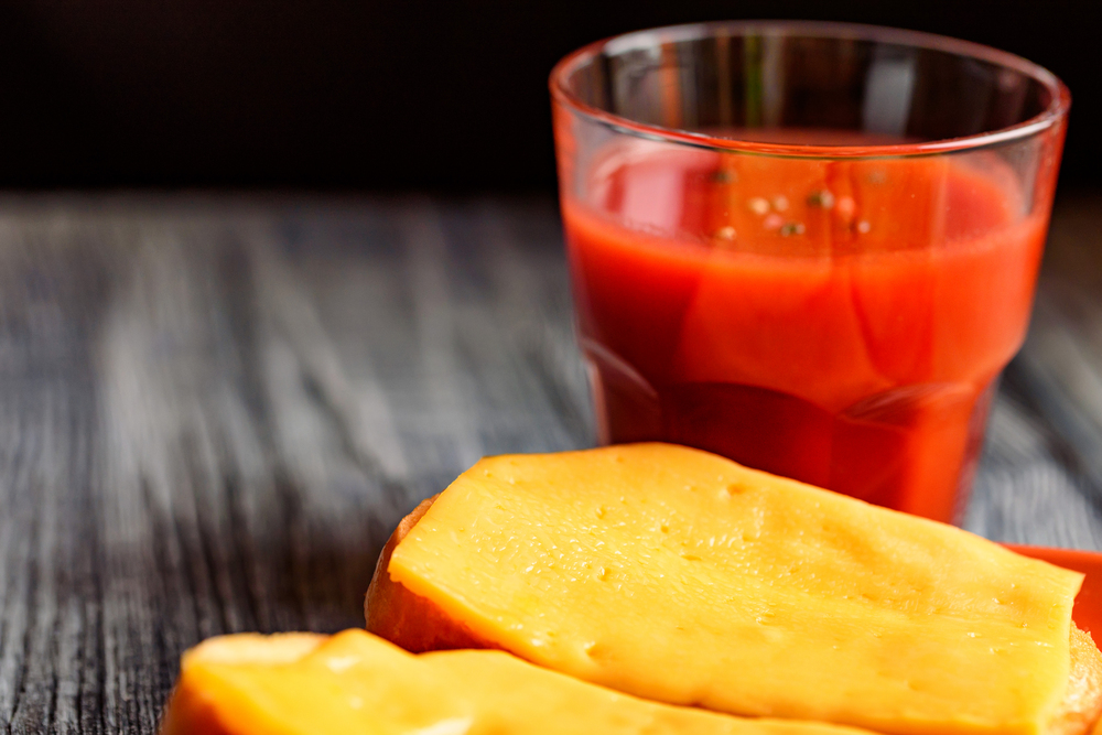 Rarebit or toasted bread with melted cheese. Grilled cheese sandwiches. Spiced tomato juice. Breakfast concept