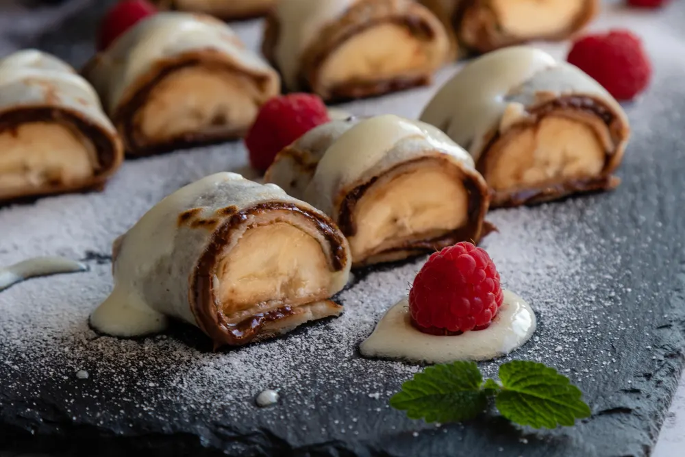 Banan pancake sushi dessert with dip and chocolate syrup