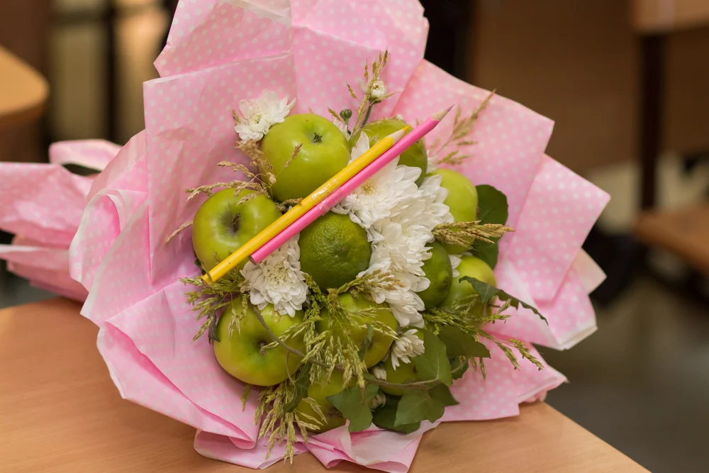 Fruit bouquet of a schoolboy. Apples, lemon, leaves, pencils