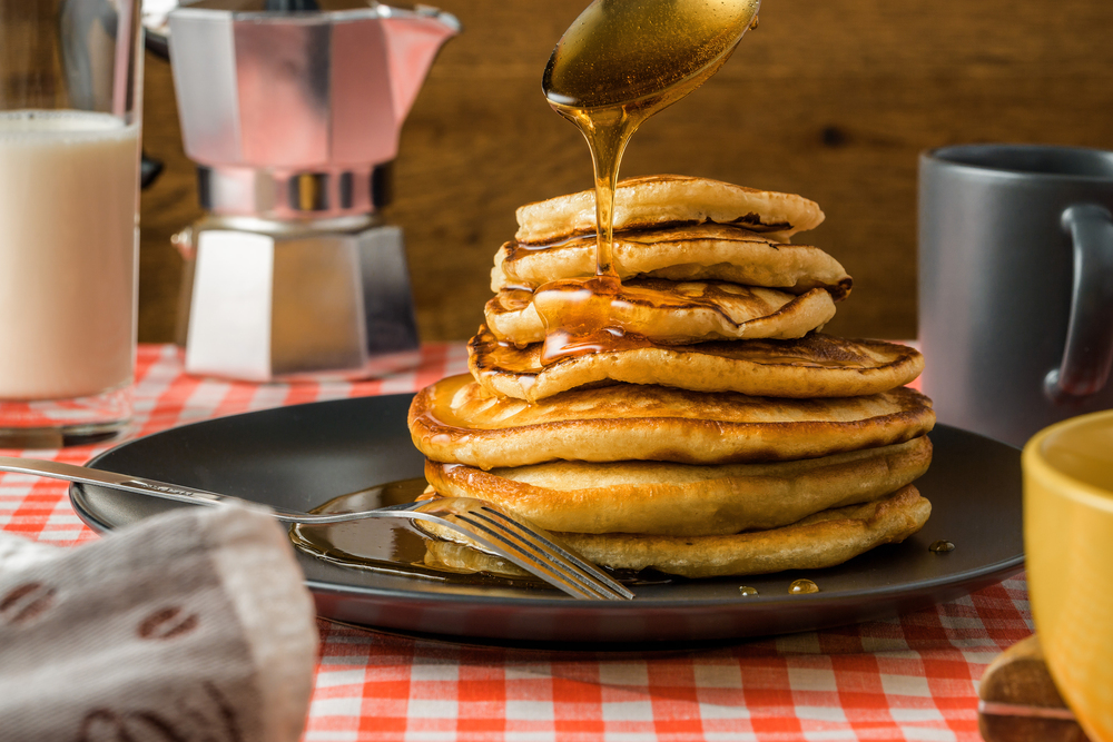 Delicious pancakes with milk and coffee for breakfast on the bac — Stock Photo, Image