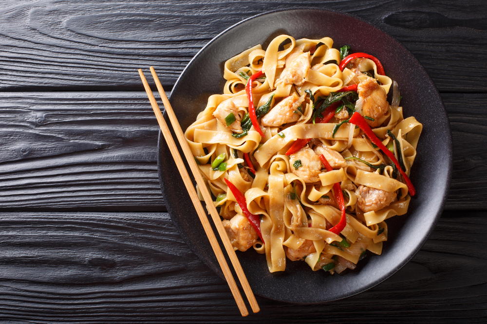 This stir-fry of wide rice noodles with chicken and fresh basil — Stock Photo, Image