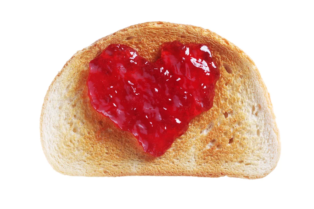 Fried white bread with heart shape strawberry jam