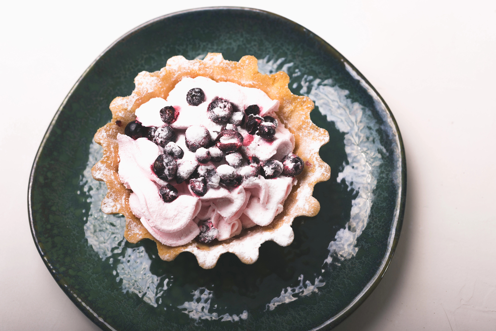Photo of a tartlet in a green plate over white background. — Stock Photo, Image