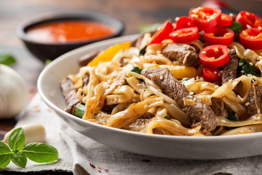 Stir fry Beef Chow Fun with rice noodles, bean sprouts, spring onions and chili. — Stock Photo, Image