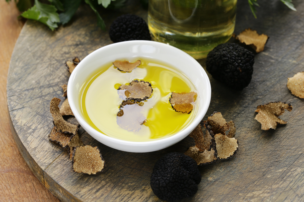 Olive oil flavored with black truffle on a wooden table — Stock Photo, Image
