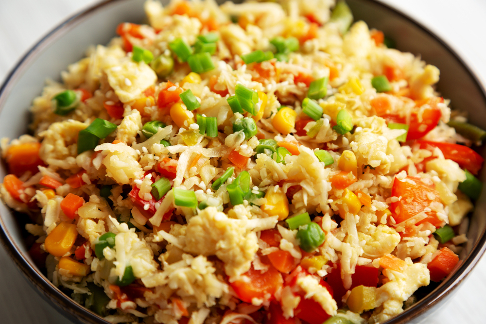 Homemade Cauliflower Fried Rice with Chives and Sesame Seeds in a Bowl, side view. Close-up.