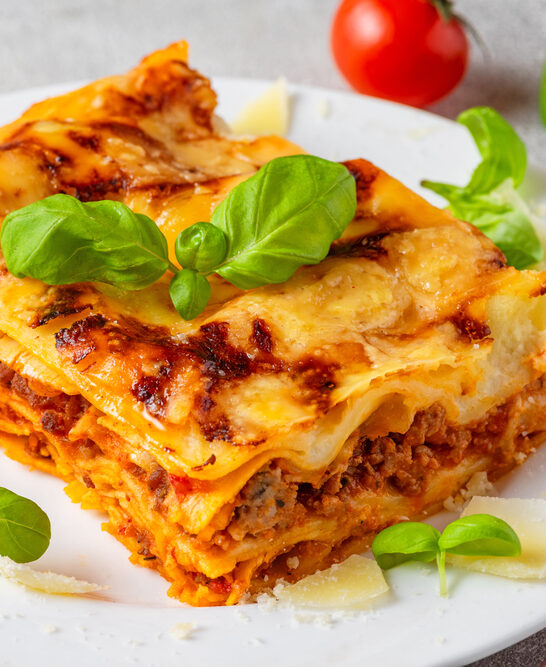 Close Meat Lasagna Fresh Basil Tomatoes Parmesan Cheese Plate Italian — Stock Photo, Image