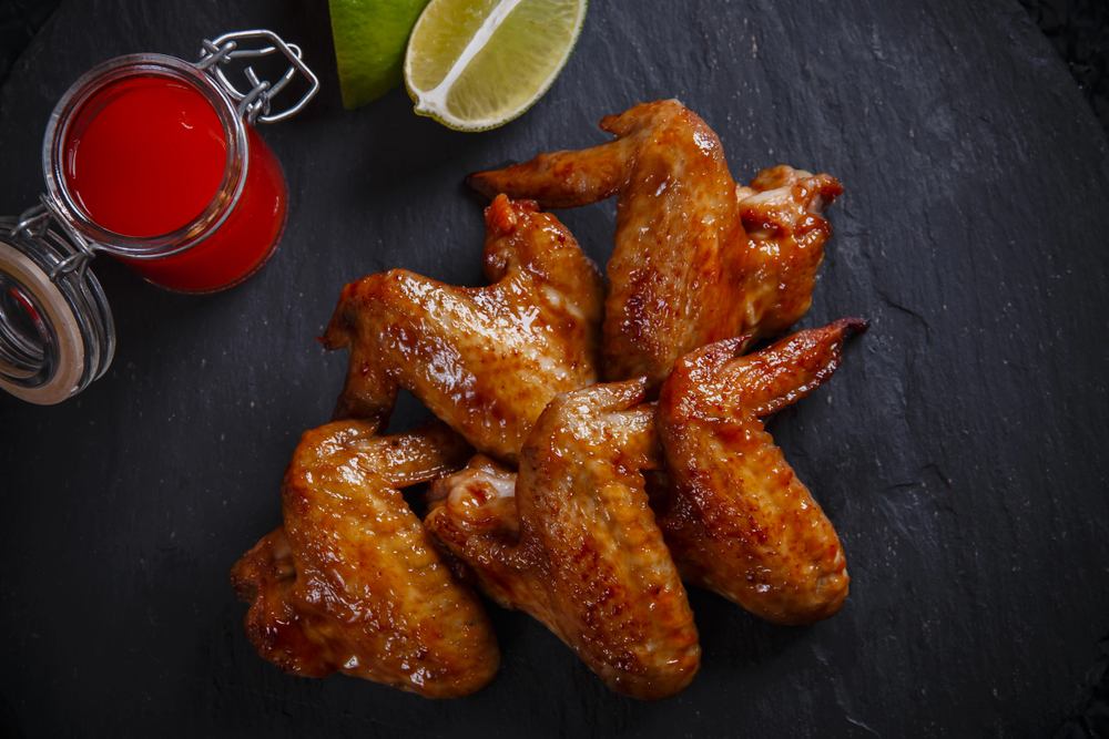 Fried chicken wings on a black stone — Stock Photo, Image