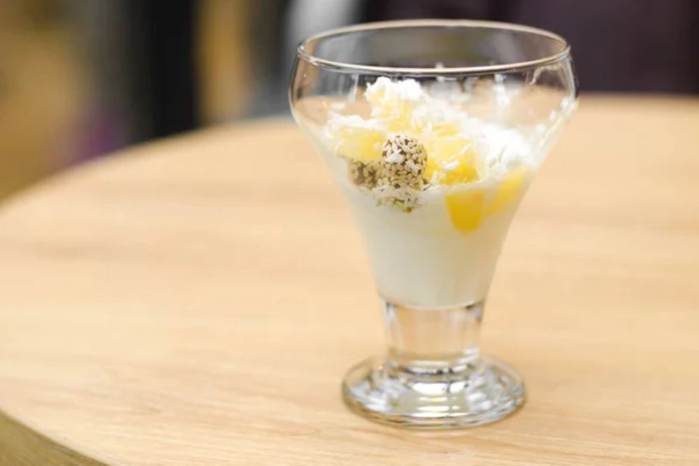 White ice cream with pineapple, coconut and nuts in glass