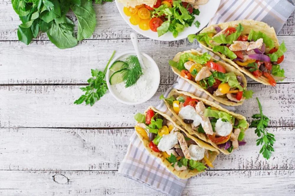 Mexican tacos with chicken, bell peppers, black beans and fresh vegetables and tartar sauce — Stock Photo, Image