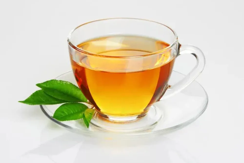 Cup with tea and green leaf — Stock Photo, Image