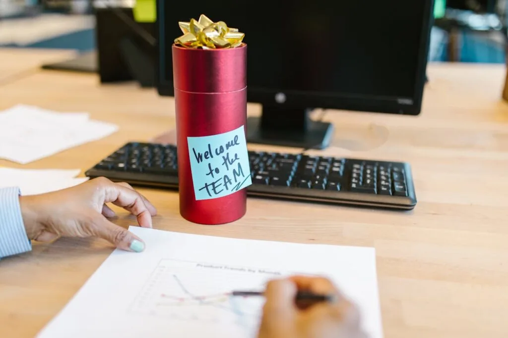 A welcome gift with a note saying welcome to the team sitting on an employees desk
