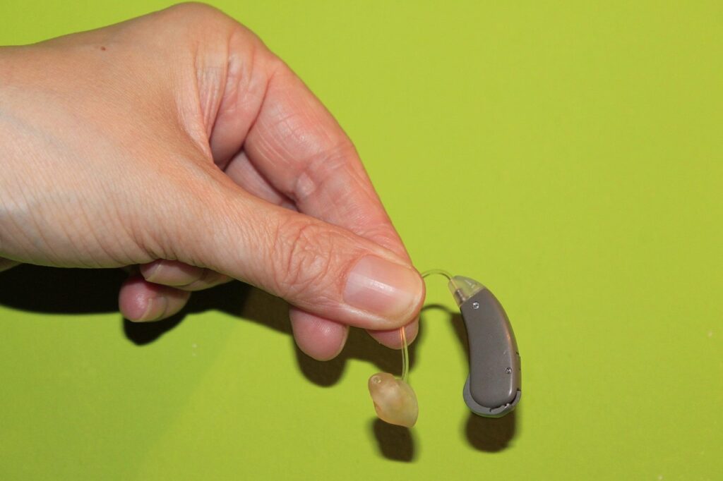 person holding a hearing aid