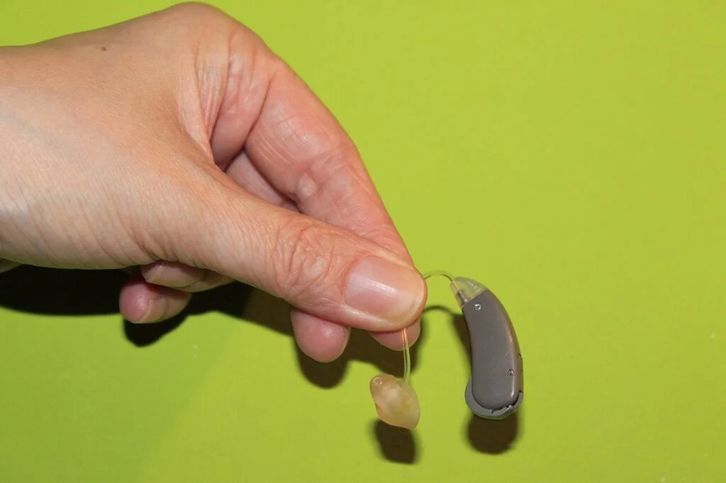 person holding a hearing aid