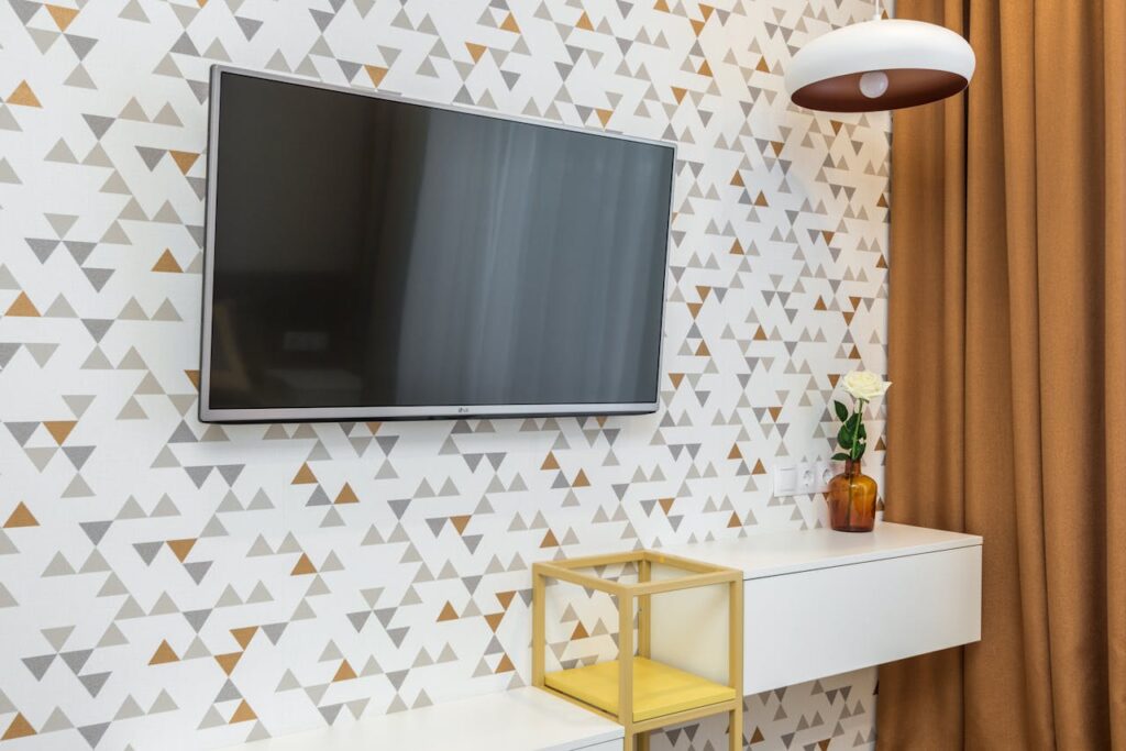 wallpaper in a geometric design with a television hung on it