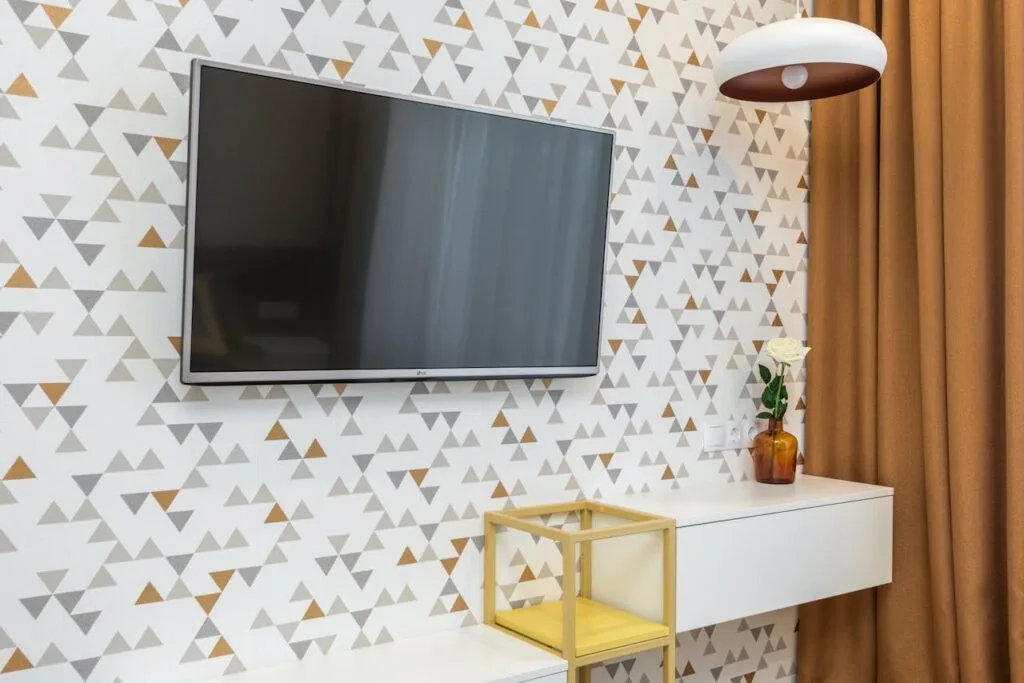 wallpaper in a geometric design with a television hung on it