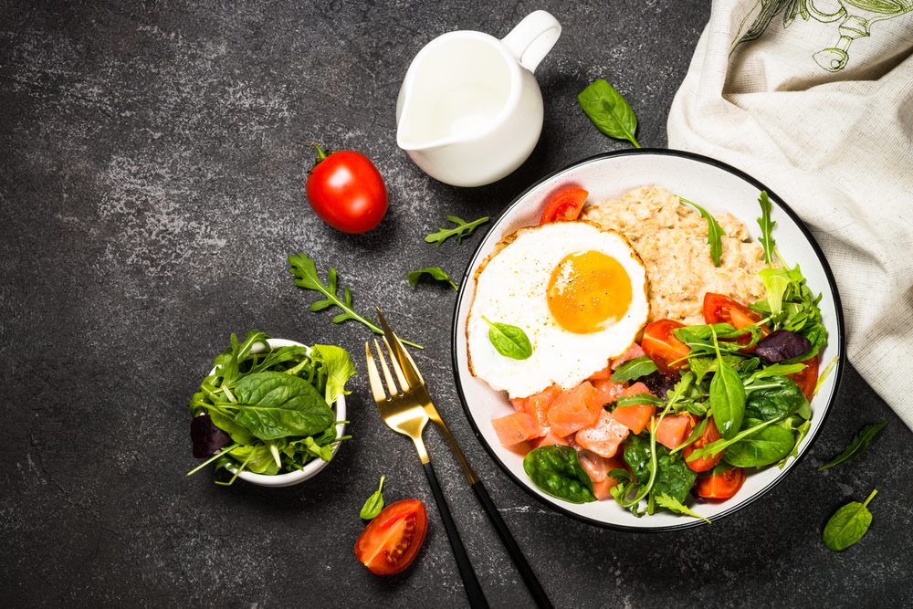 Savory breakfast with oatmeal, salmon and salad. — Stock Photo, Image