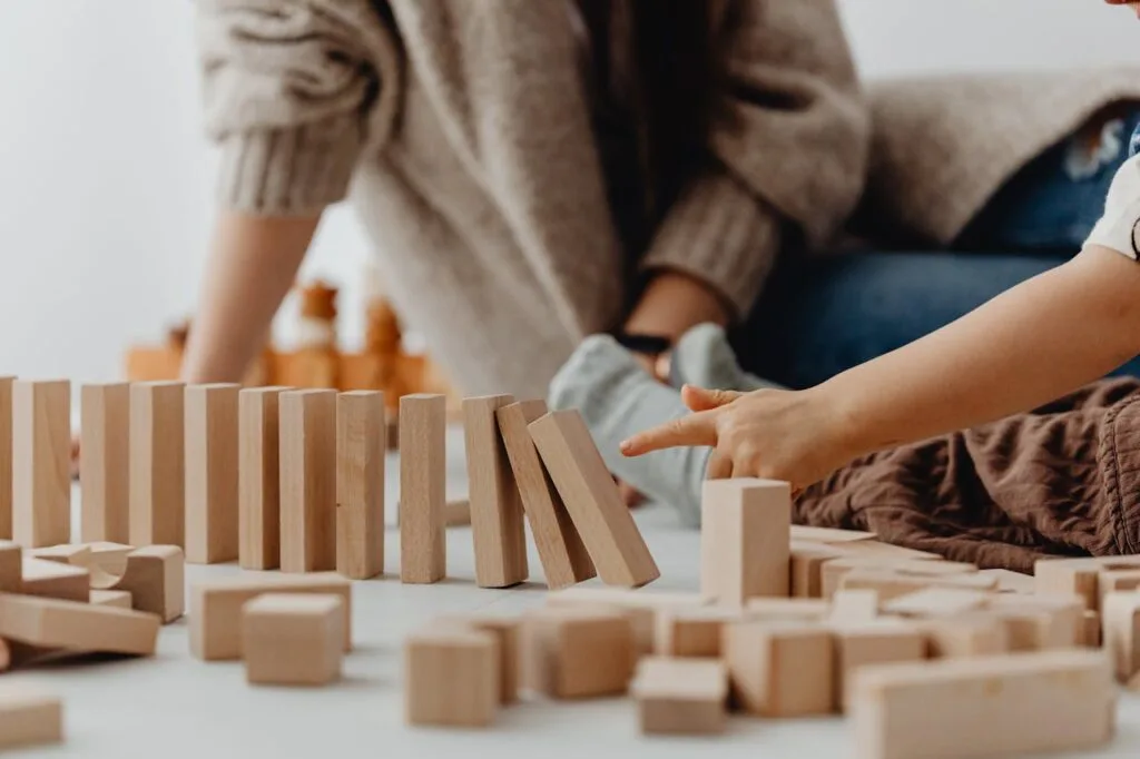 A teacher working with a child building with blocks