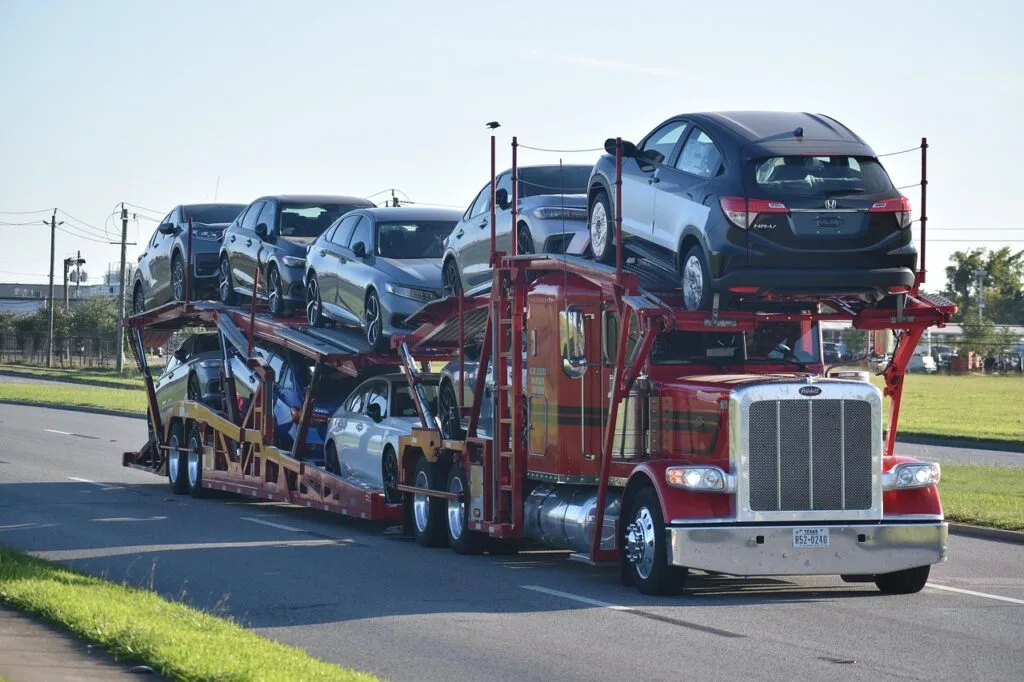 A red 18 wheeler carrying a load of cars