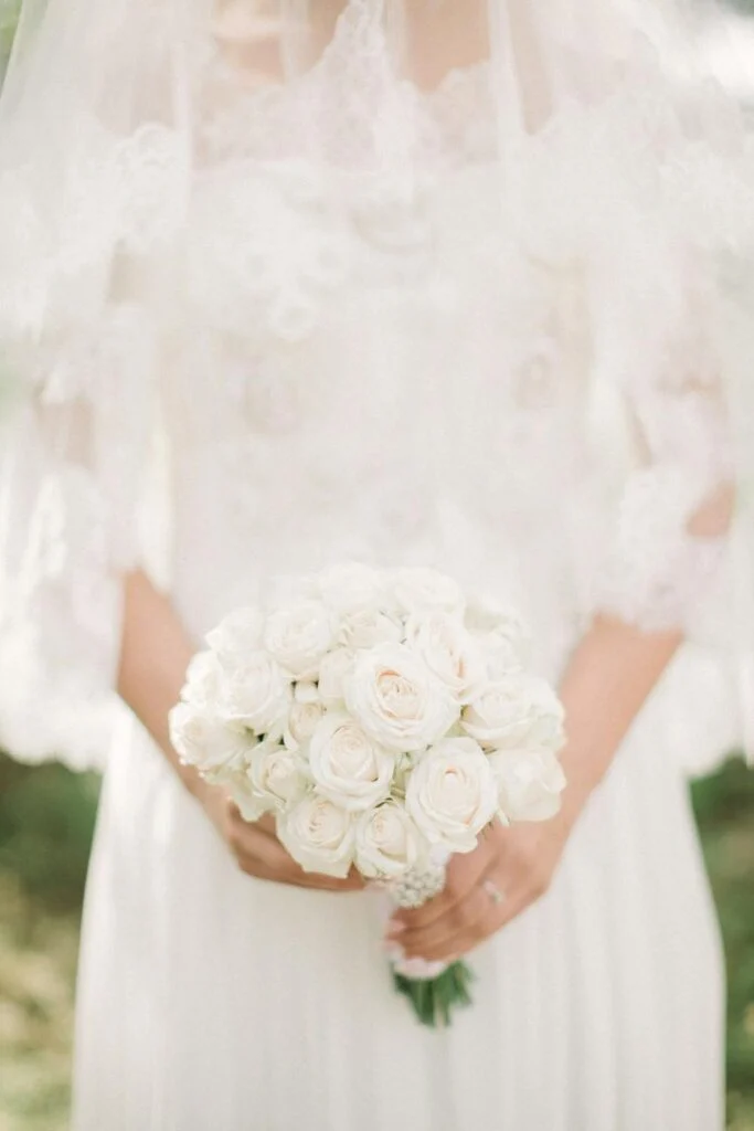 The front of a bride wearing her dress and holding her bouquet