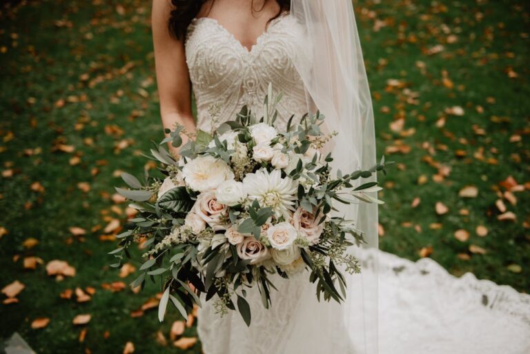 a gorgeous bouquet of flowers held by a lady in a wedding gown