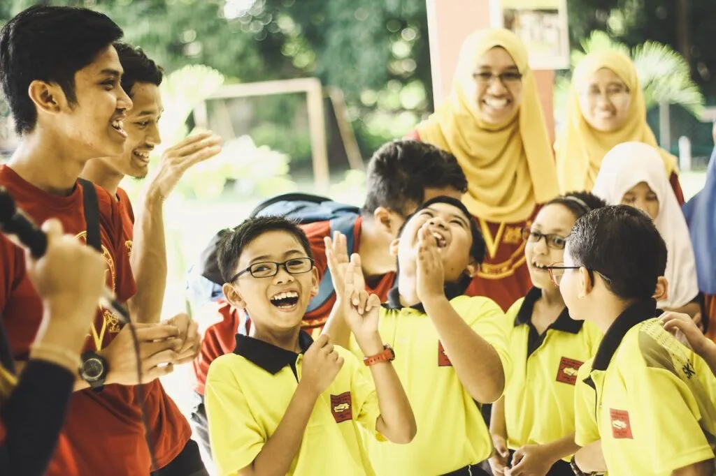 A group of kids and teachers laughing in a class that uses  inclusive teaching strategies