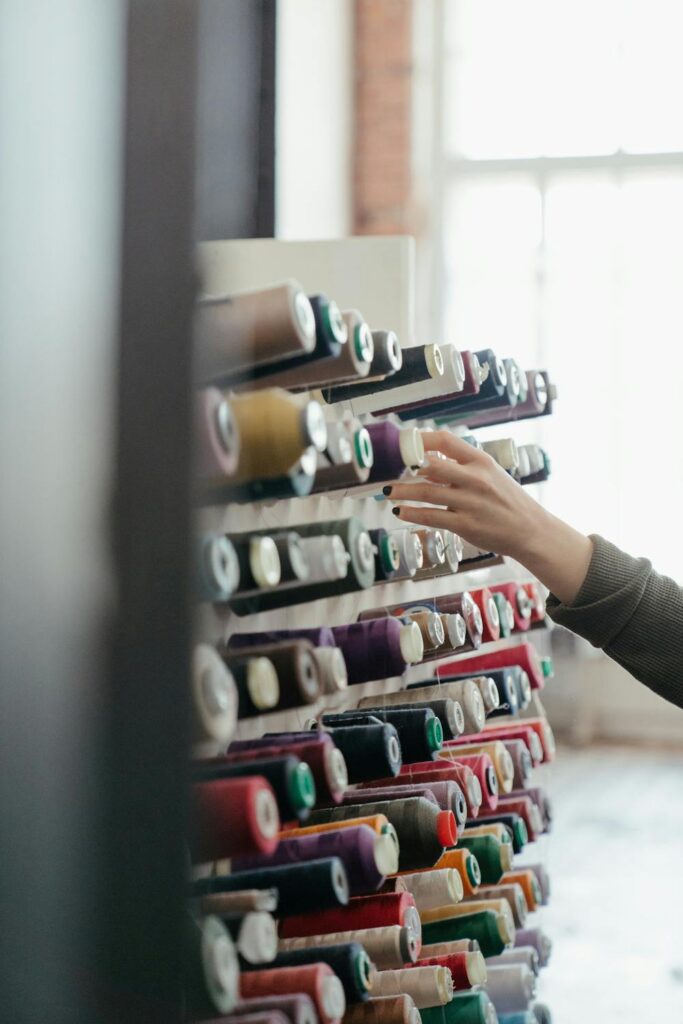 Spools of crafting yarn organized on a wall hanger