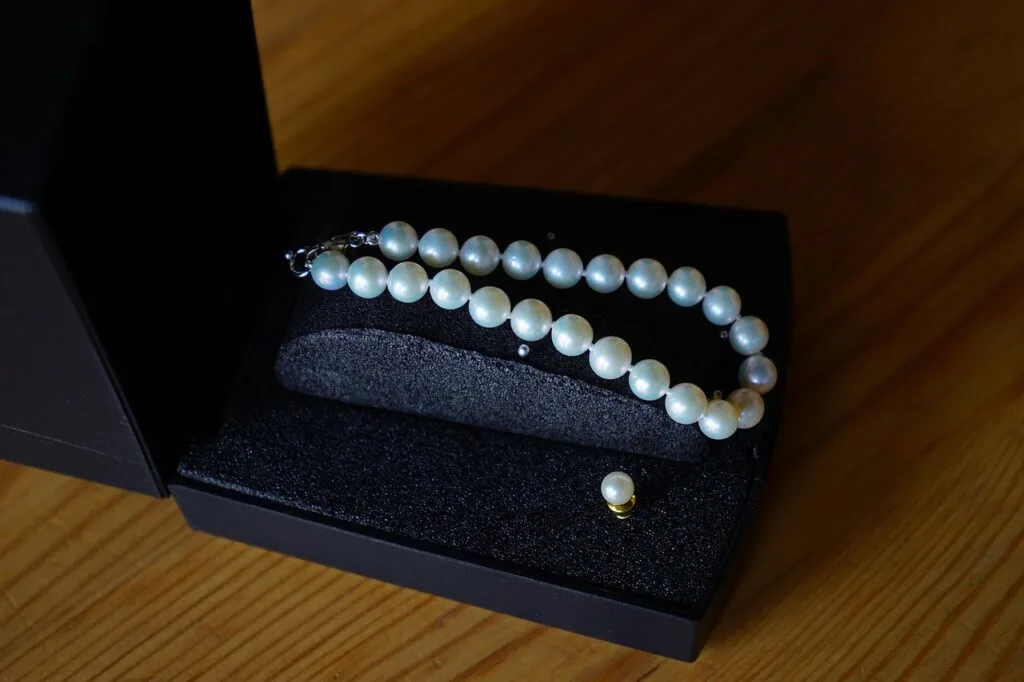 A pearl bracelet and earrings in a black case