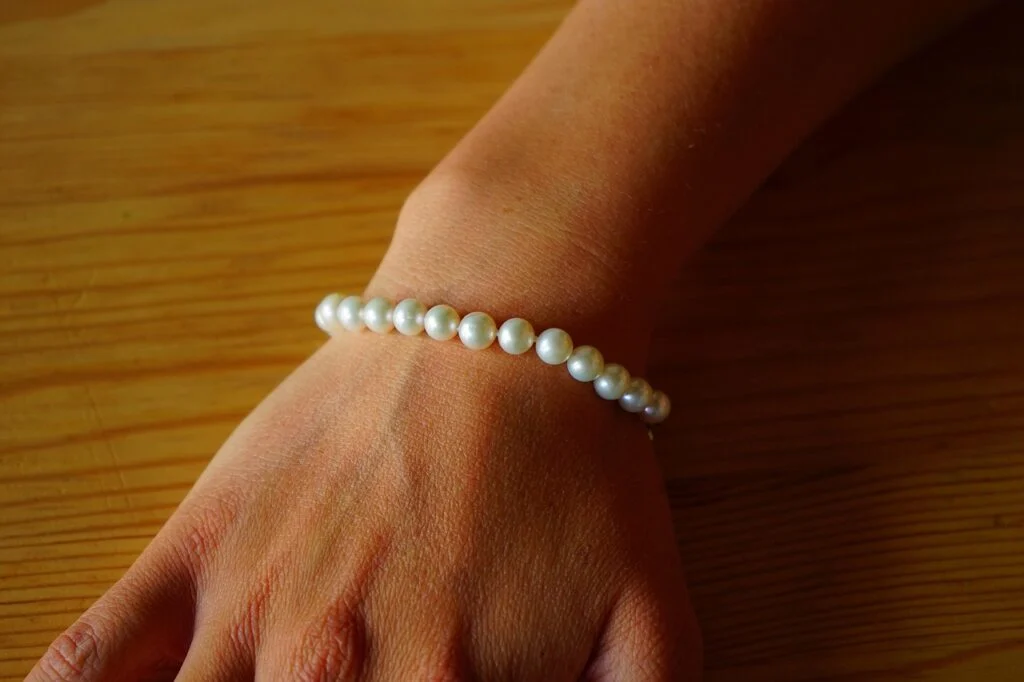 A lady wearing a pearl bracelet that are actually pearls on a budget she found