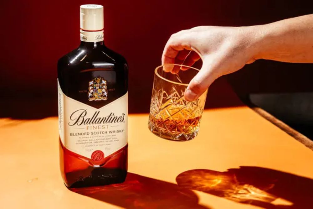 Bottle of Ballantine's Whiskey on dark background — Photo by EvaSV19