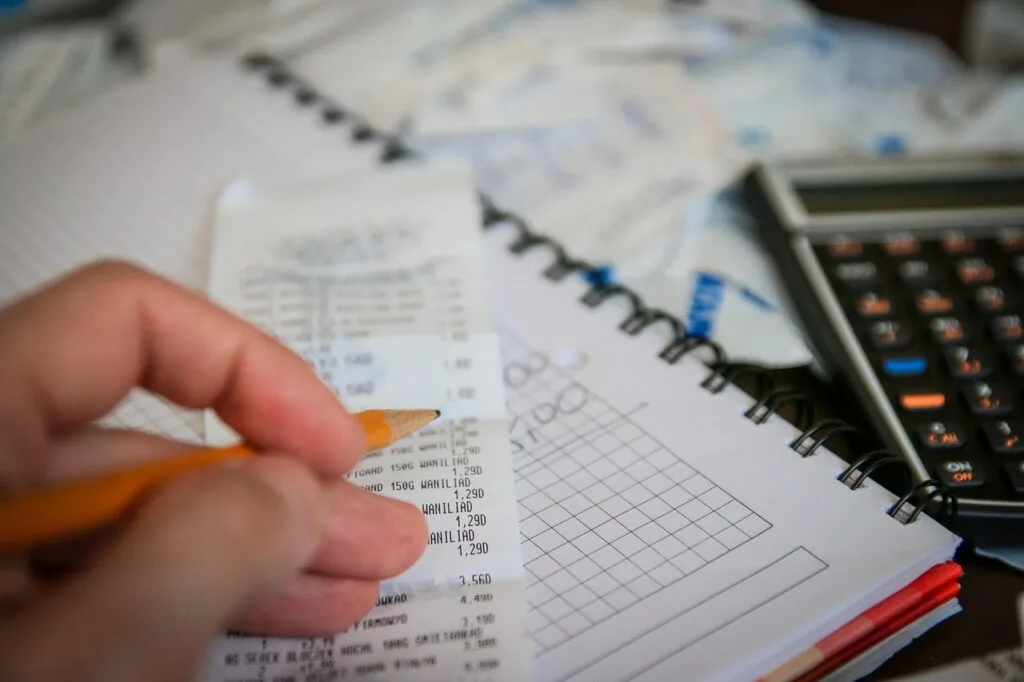 Person budgeting their spending while looking for ways to save money while shopping