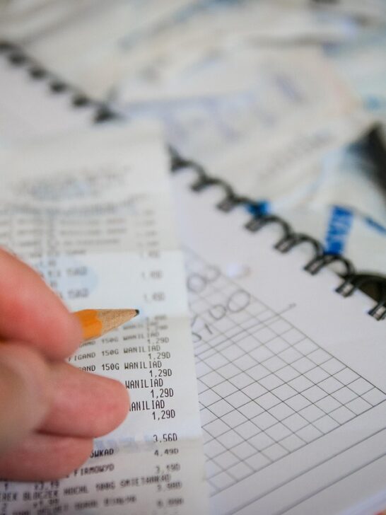 Person budgeting their spending while looking for ways to save money while shopping