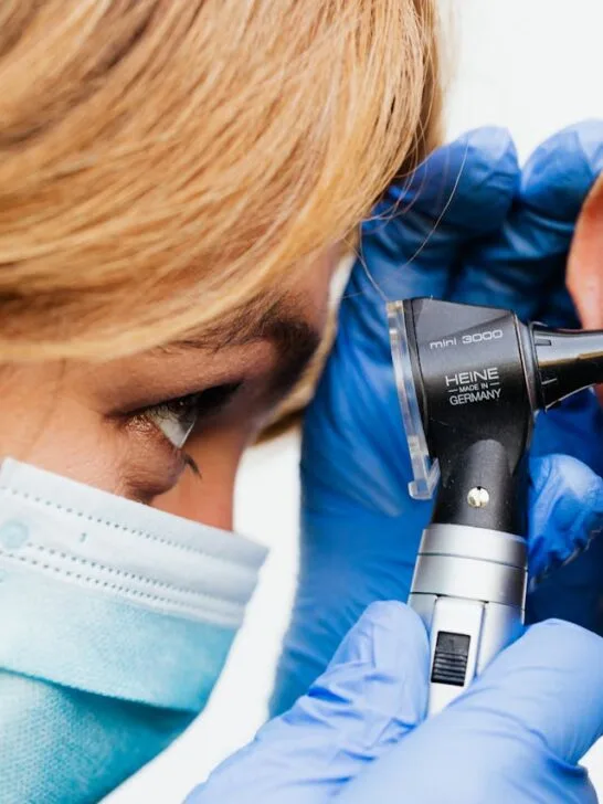 A doctor looking in her patient's ear. Learn the 9 warning signs you should have your ears examined soon