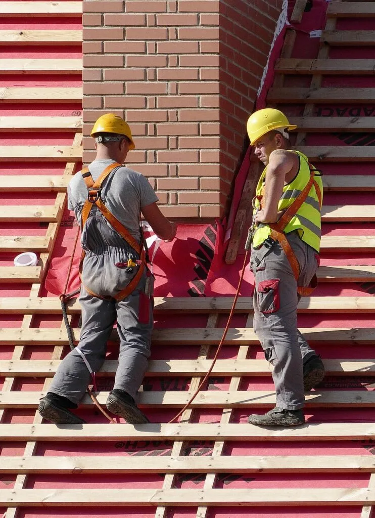 Two construction workers in appropriate clothing for their job, an example of how choosing the Right Workwear impacts safety and productivity