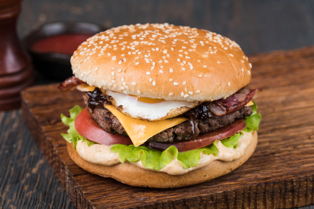 alt="Burger on a wooden board — Stock Photo, Image"