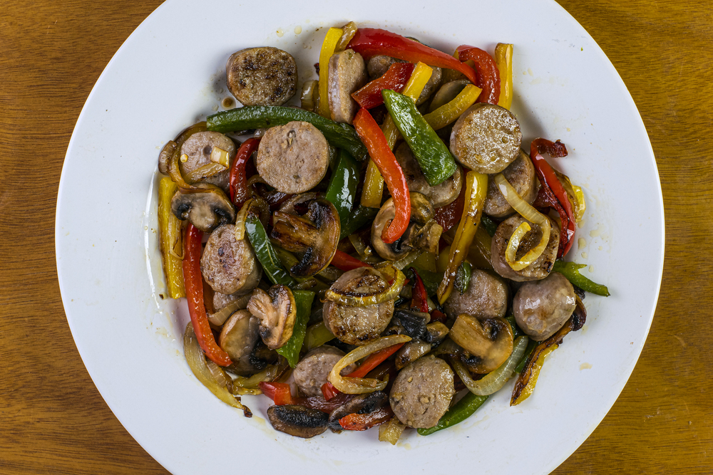 a dish consisting of sausage, onions and pepeppers with mushrooms