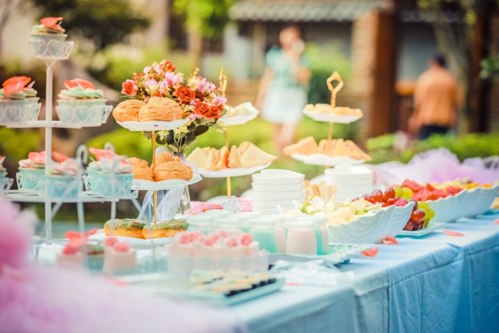 Table filled with Easy Summer Party Snacks and Drinks for Kids including fruits, sweets, finger sandwiches and more.