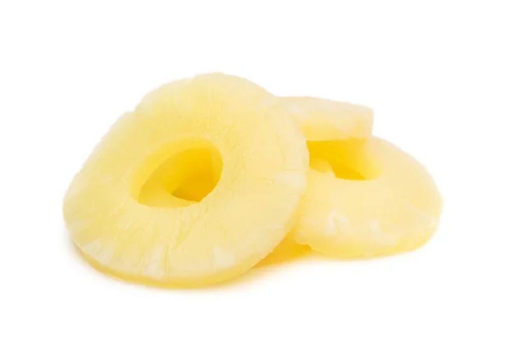 Heap of canned pineapple rings on white. — Photo