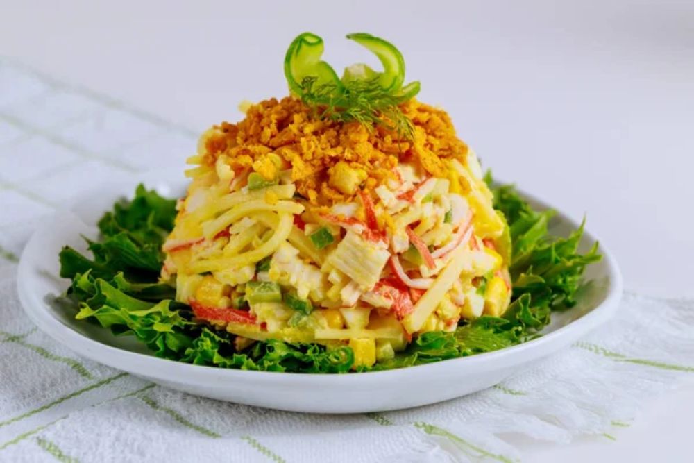 Tasty crab meat salad with corn, cucumber and eggs. Close up