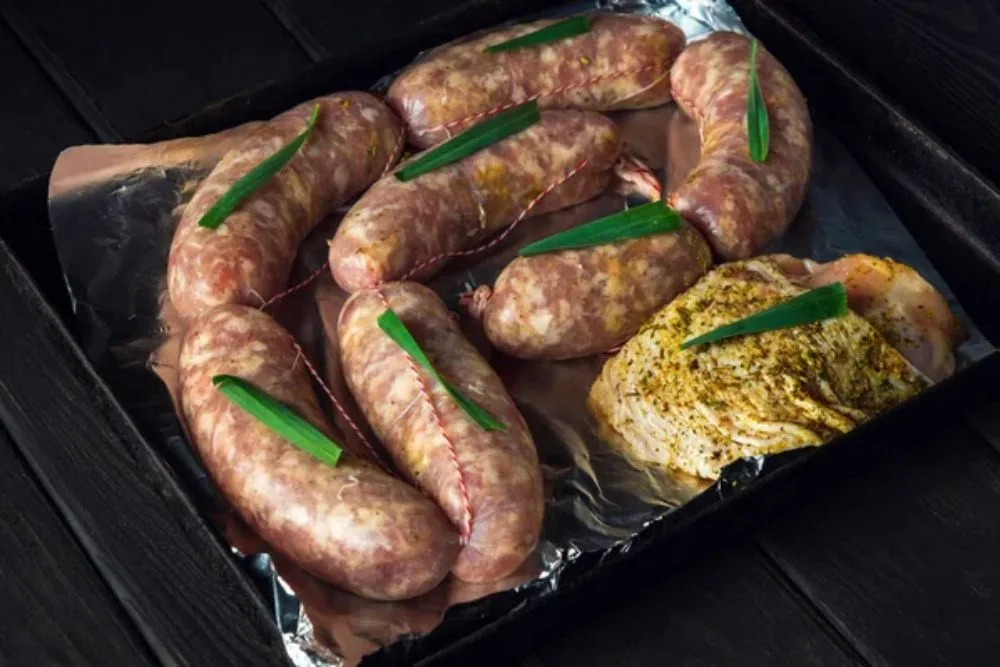 Raw meat sausage and ham on a Sheet pan is prepared