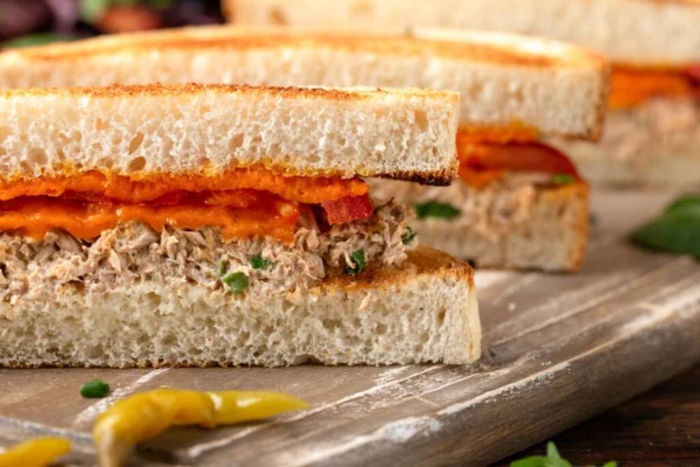 Homemade tuna melt sandwich on rustic board. — Photo