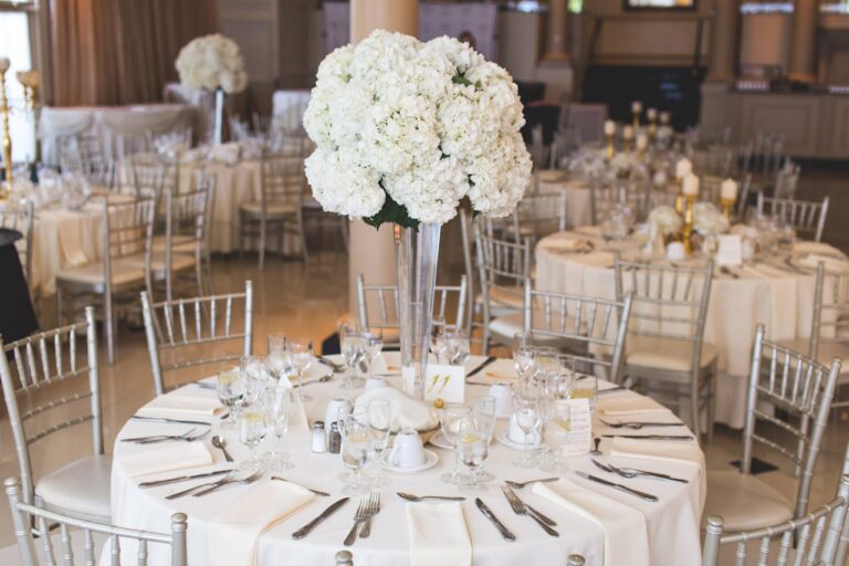 Several tables decorated in white for an affordable catered celebrations