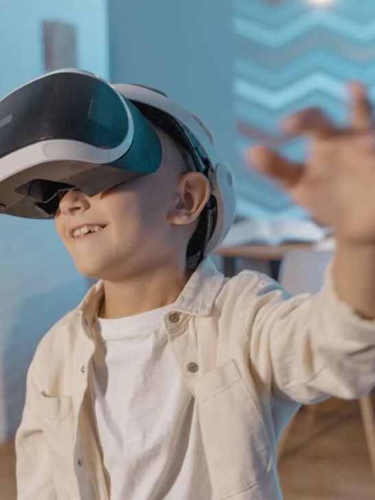 A boy wearing VR goggles which are one of the modern educational tools for kids that form immersive learning.