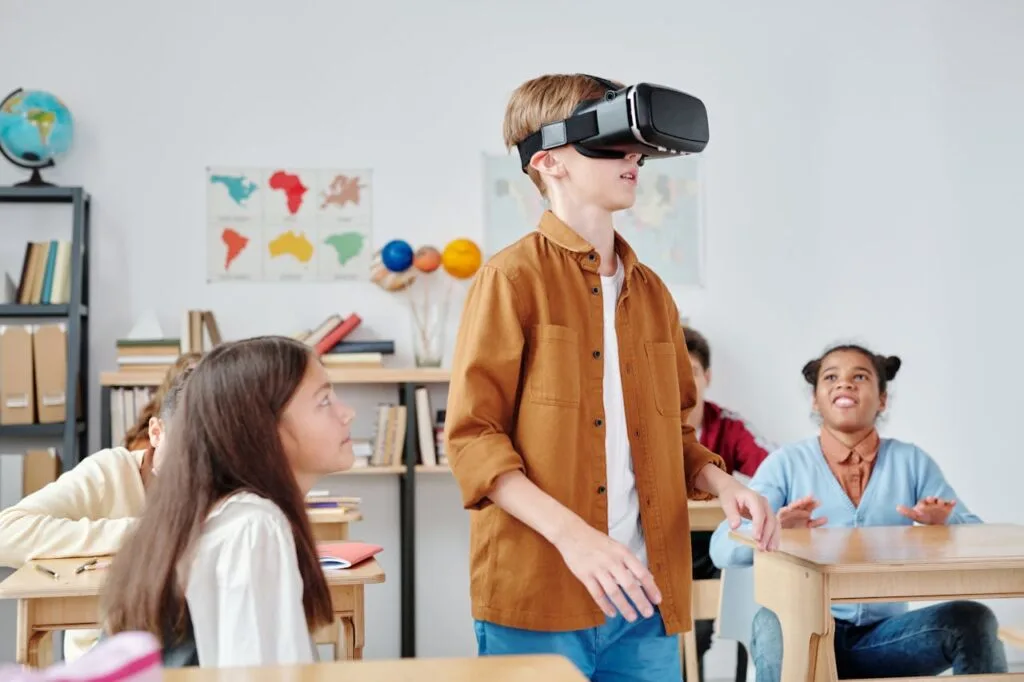A boy using a virtual reality headset in his classroom