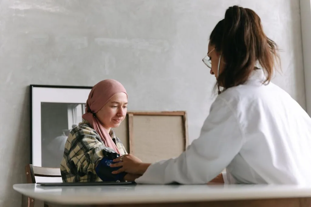 A doctor taking her patient's blood pressure. Learn why real-time medical updates could be a game-changer for cancer patients
