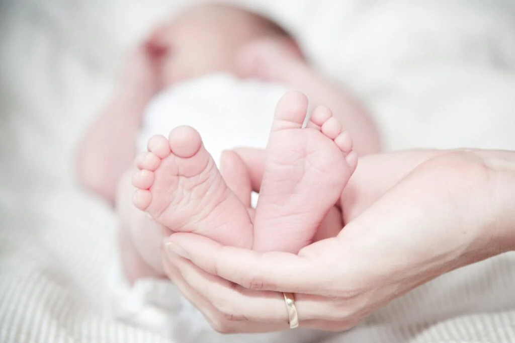 A woman holding a baby's feet in her hand