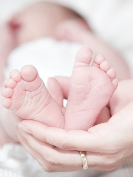 A woman holding a baby's feet in her hand