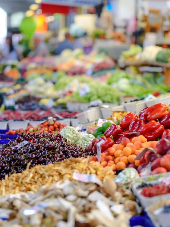 People shopping at a farmers market, one of our easy eco-friendly summer tips for green living.