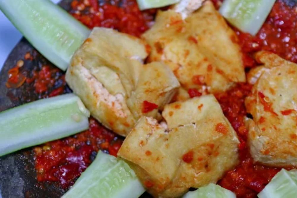 Fried tofu served with spicy sambal and fresh cucumber slices,